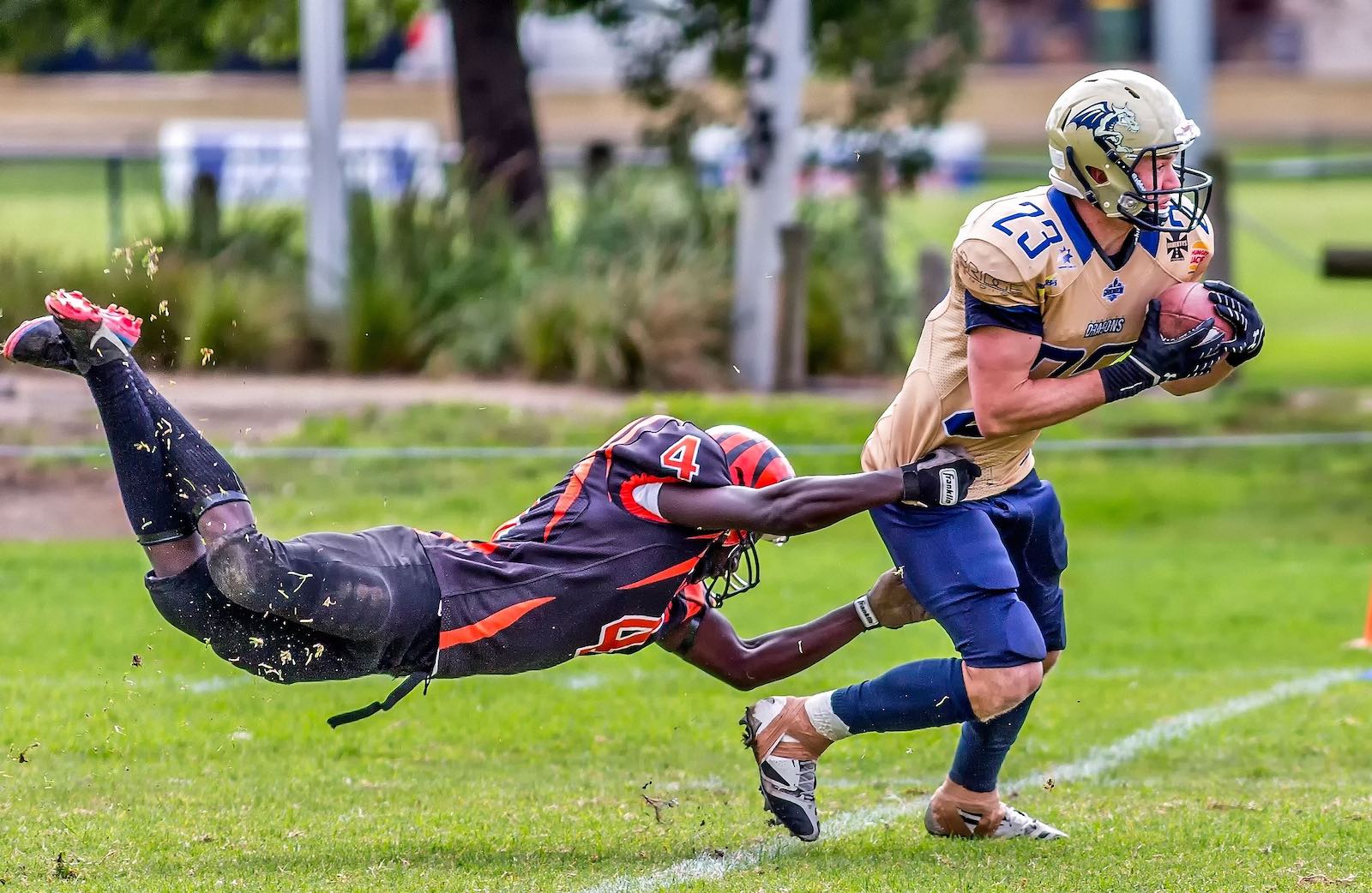 2 men playing american football. One is trying to tackle the other.